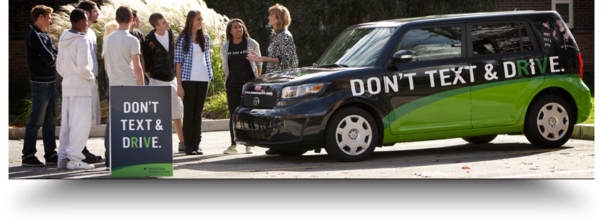 Community members gathered beside the Don't Text & Drive campaign vehicle